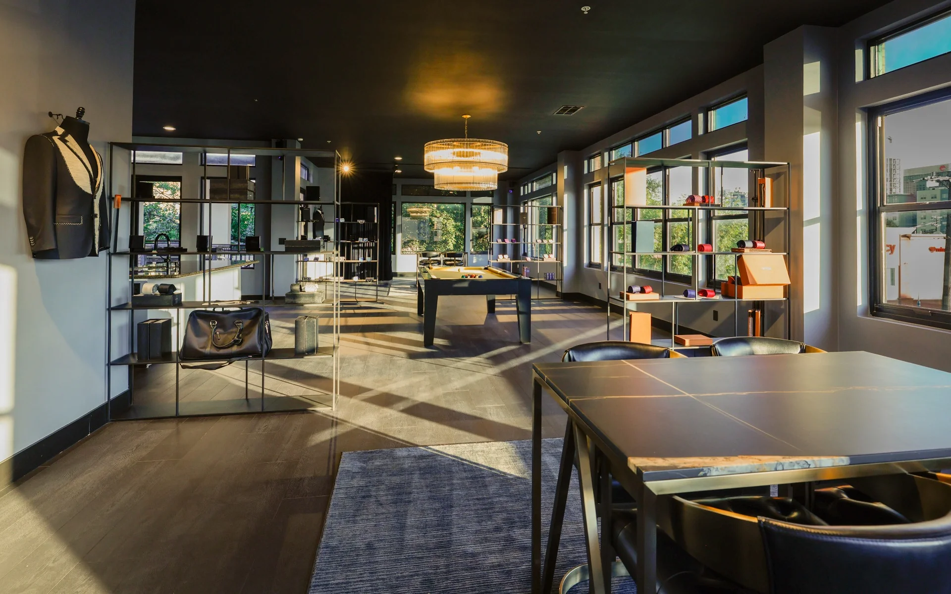 The Enzo Custom Dallas showroom, with warm sunlight, leather seating, a consultation table and tailoring displays